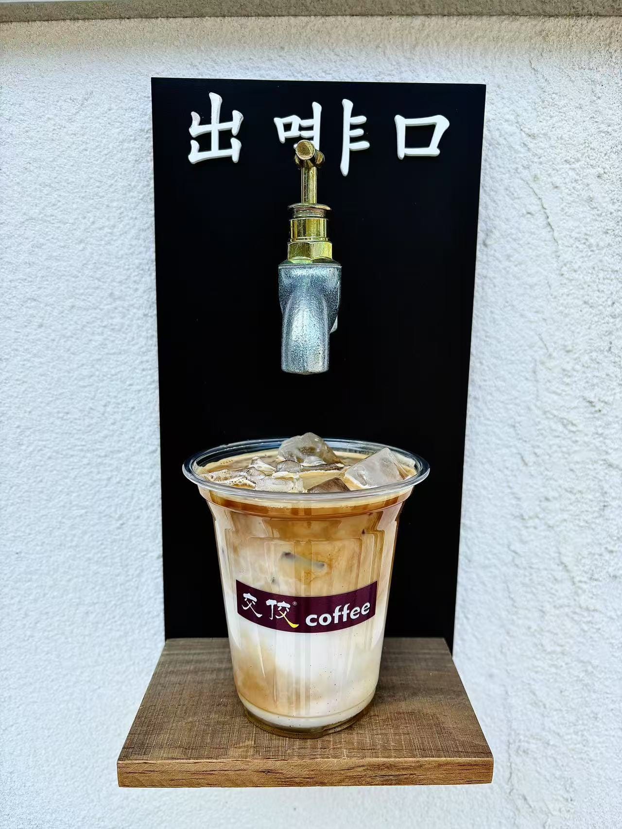 交佼咖啡的出啡口装饰与一杯冰奶咖